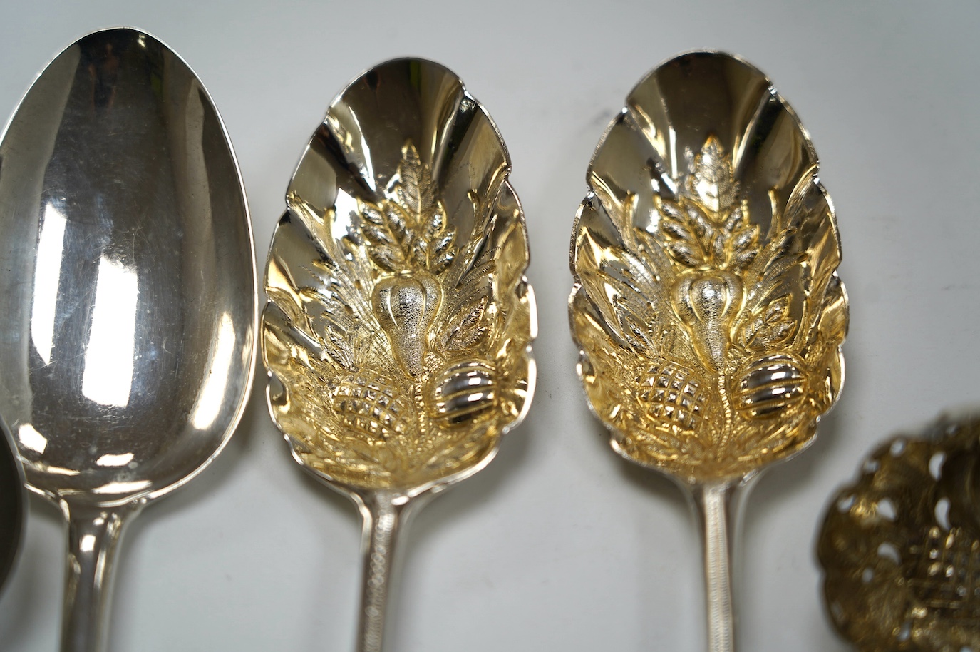 A pair of George III silver berry spoons, London, 1804, together with three other spoons, including a Georgian Scottish table spoon and a George III silver berry sifter spoon, Eley, Fearn & Chawner, London, 1809, 10.6oz.